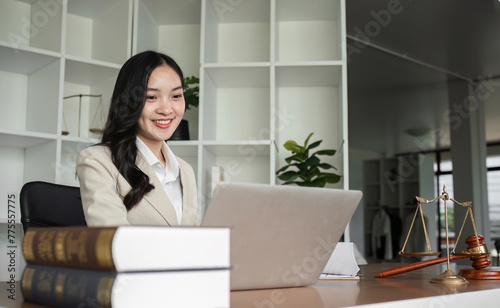 A female Asian lawyer reviews business and real estate laws. Legal consultants provide legal advice and guidance online via laptops in lawyers' offices.