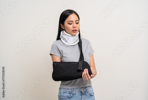 Depressed upset woman suffering from pain. Broken arm. Asian woman put on plaster bandage cast splint. Patient wearing sling support arm after accident injury. life insurance and accident photo