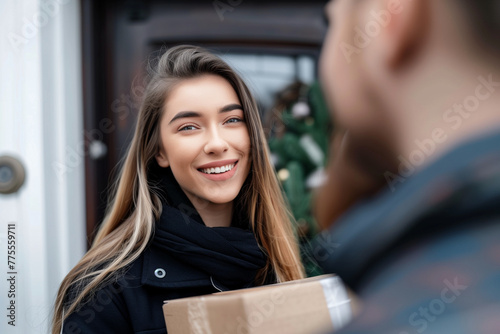 smiling woman receiving an elegant package from the delivery man at her front door