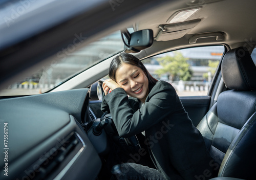 Young beautiful asian business women getting new car. Happy smiling female driving vehicle on the road hugging steering wheel touching detail car interior. Business woman buying driving new car © Chanakon