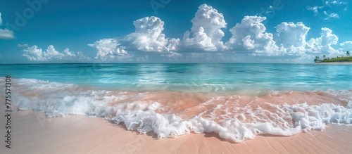 Beautiful white sand beach and calm waves of the turquoise ocean on a sunny day on the background of white clouds in the blue sky. Beautiful colors. Natural landscape. photo