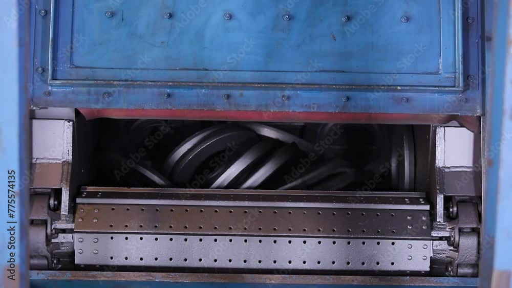 automatic shot blasting machine, for cleaning forged components, fettling process of metal parts in a large machine rotating rounds in a forging and machining foundry factory