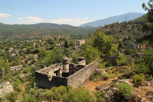 View on the abandoned village of Kayaköy, Livissi with a traditional house with chimney and without roof in the foreground, close to Fethiye, Turkey