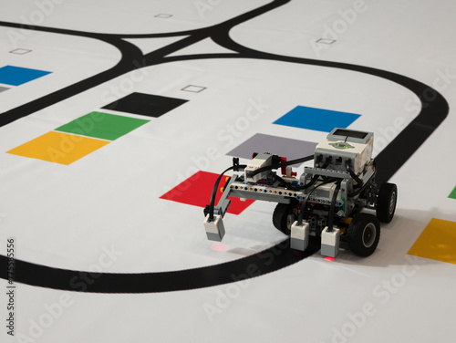 Robot with wheels is moving along the black line. Line following with a sensor