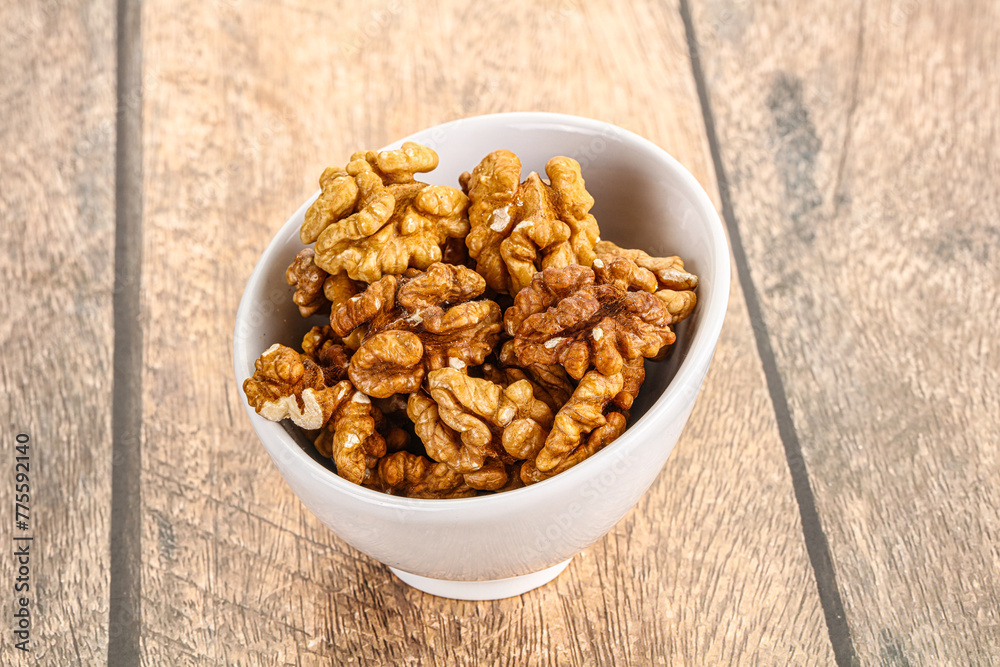 Cracked unshelled walnut in the bowl Cracked unshelled walnut in the bowl