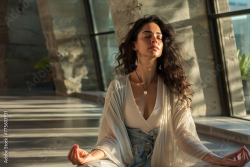 young latin woman meditating in the lotus pose wearing relaxed loose clothing