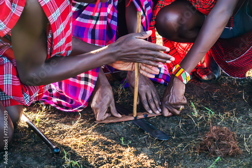 Making a fire by friction is most ancient way of making fire. It was used by ancient people, starting from the origins of history. Maasai mans making fire. photo