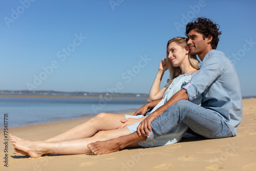 happy couple siting on beach romantic man and woman © auremar