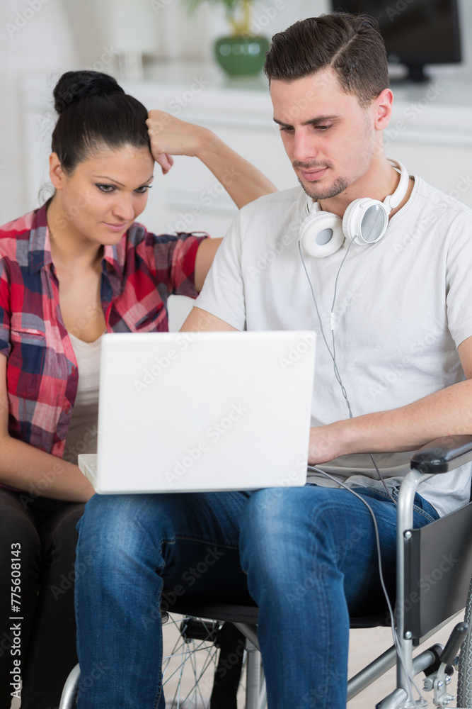 disabled man surfing on internet with his girlfriend disabled man surfing on internet with his girlfriend