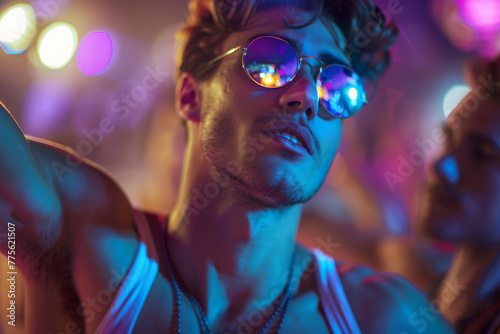 Handsome young gay man in a gay club dancing on a guy