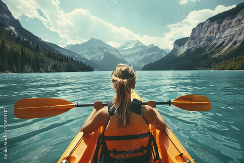 young woman rowing in a kayak on the lake, back view photo