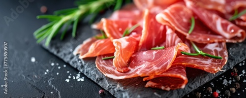 Spanish jamon ham sliced on black modern slate top view. banner.