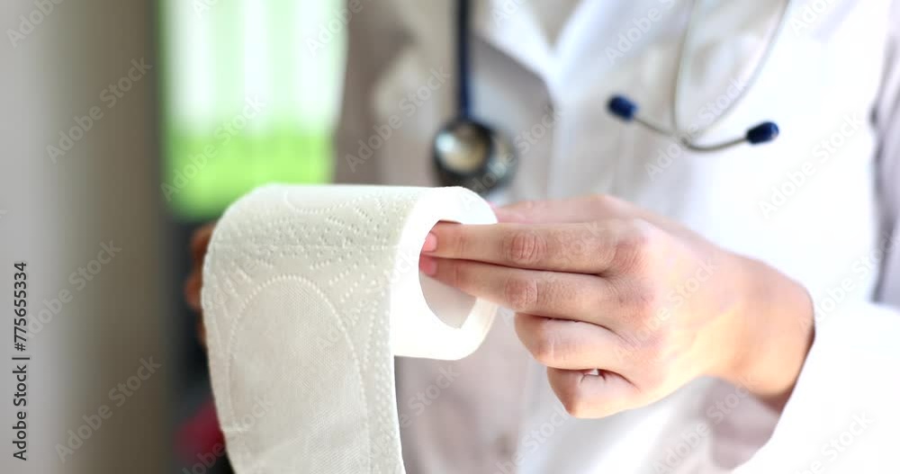 Doctor demonstrates roll of toilet paper and problems with diarrhea. Paper towel for hospital patients Doctor demonstrates roll of toilet paper and problems with diarrhea. Paper towel for hospital patients