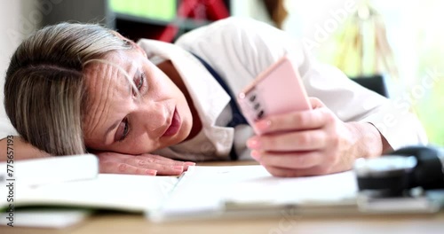 Worried medical doctor using smartphone and texting in doctor office. Fatigue depression stress and medical therapist photo