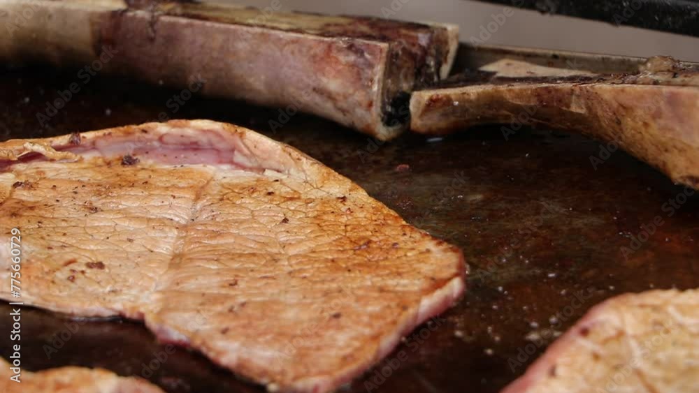 Carne asada y tuetanos preparandose y cociendose en parrilla
