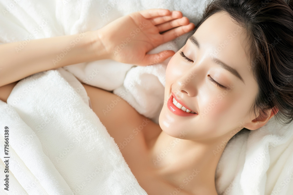 Close-up shot capturing a serene woman wrapped in a soft towel with a gentle smile