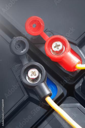 The terminals of lead acid batteries connected in series. Closeup view on positive and negative plugs with wires.