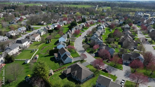 Small town in America at sunny day in spring. Homes in quiet quaint residential housing district of USA. Aerial drone establishing shot. photo