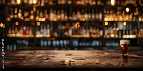 A glass of beer is placed on top of a wooden table in a moody cafe setting photo