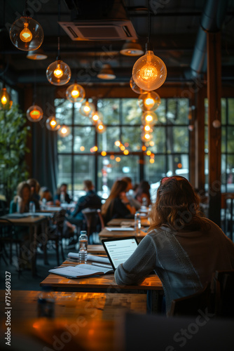 A person attending a workshop on tax-efficient investing strategies. Woman at table in restaurant with laptop  surrounded by darkness in city event