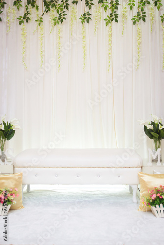 Minimalist Malay wedding stage decorations with flowers and leaf.