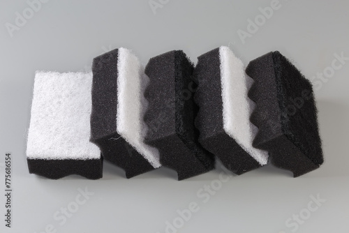 Black and white synthetic cleaning sponges on a gray background