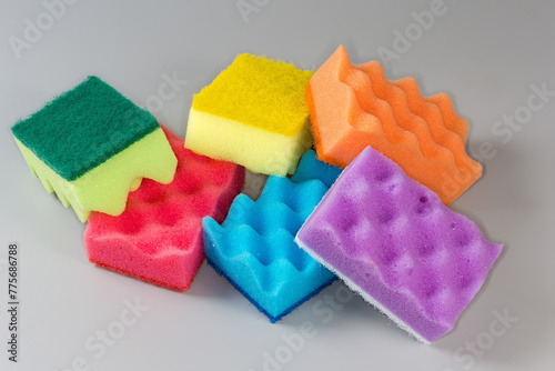 Multi colored synthetic cleaning sponges on a gray background