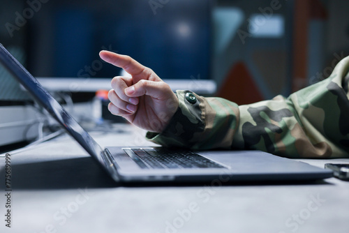 close up solider man officer hand point on monitoring program to control about radar or satellite signal at dark operation room in military station for technology and security concept photo