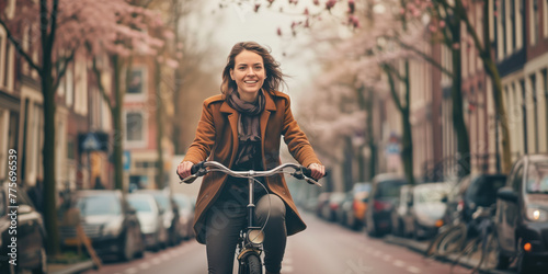 Young cheerful woman having fun riding a bicycle in Amsterdam city on spring day.