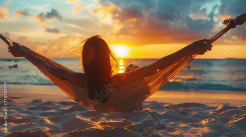Contraluz de mujer tumbada en una hamaca en la playa en verano viendo el atardecer. Mujer descansando en hamaca al atardecer en la orilla de la playa. photo