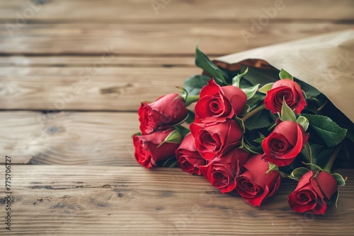 love, date, flowers, valentines day and holidays concept - close up of red roses bunch wrapped into brown paper on wooden table
