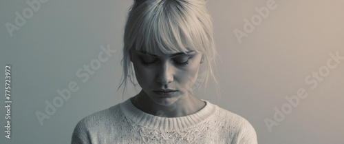 A woman with a soft gradient face looks down with regret
