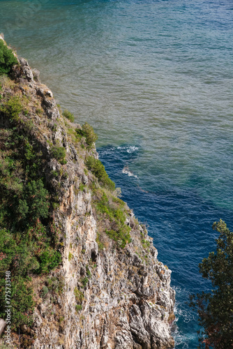 Cliffside next to the dark blue sea at the amlfi coast in italy.