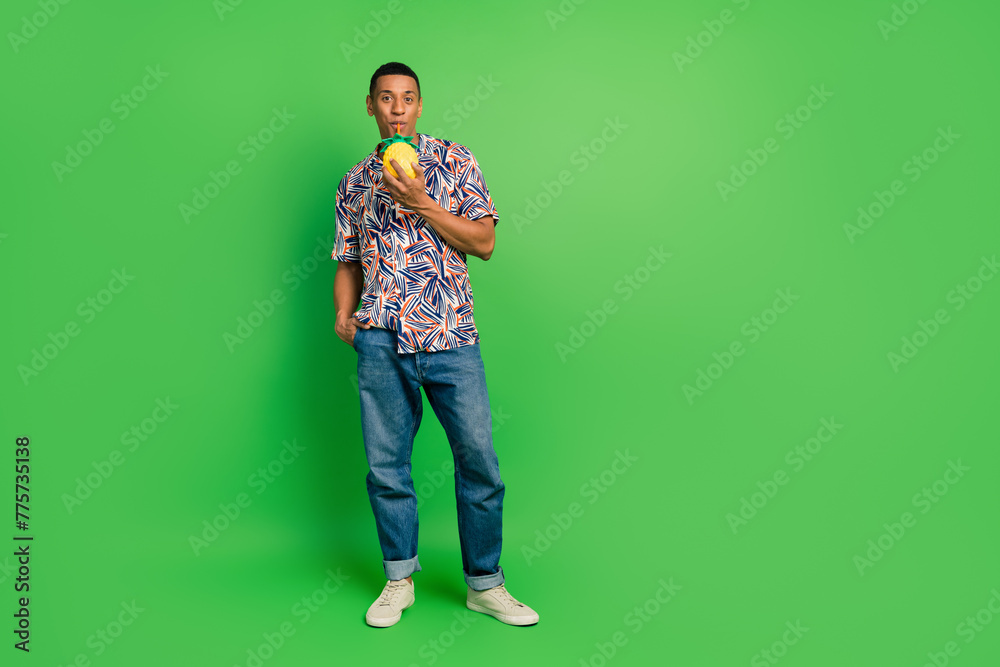 Full body photo of nice positive man sipping straw pineapple cocktail empty space isolated on green color background