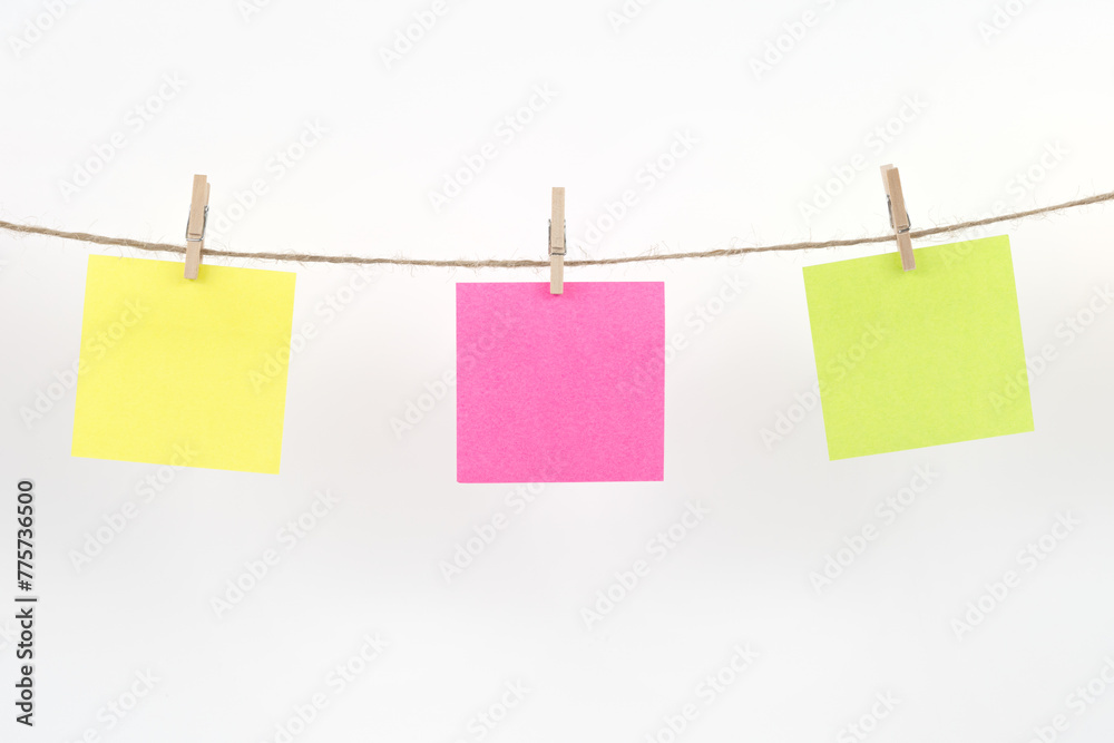 Wooden clothespins with blank notepapers on twine against isolated white background space for text. note blank color paper cards on rope. blanks for designers Wooden clothespins with blank notepapers on twine against isolated white background space for text. note blank color paper cards on rope. blanks for designers
