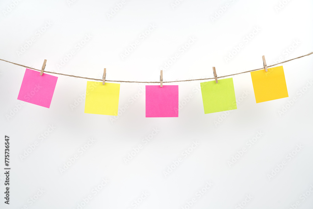Wooden clothespins with blank notepapers on twine against isolated white background space for text. note blank color paper cards on rope. blanks for designers Wooden clothespins with blank notepapers on twine against isolated white background space for text. note blank color paper cards on rope. blanks for designers