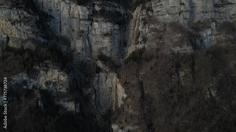 A beautiful waterfall falling on the dark rocks of the Swiss Alps in the early evening. A drone view of a destination sought after by tourists A beautiful waterfall falling on the dark rocks of the Swiss Alps in the early evening. A drone view of a destination sought after by tourists