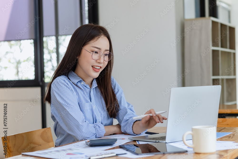 Asian businesswoman working with digital laptop computer and document management at desk in office. Asian businesswoman working with digital laptop computer and document management at desk in office.