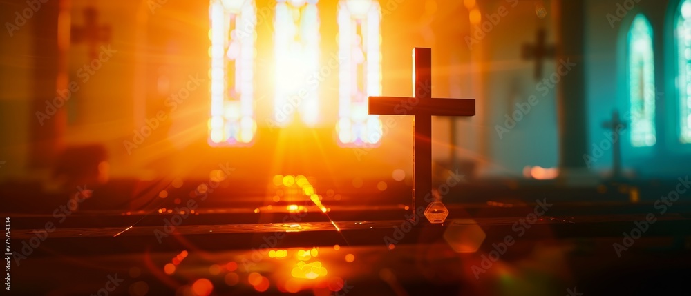 The silhouette of a cross in a church interior with stained glass windows as a concept for prayer and religion is abstractly defocused