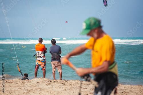 Active sporty people enjoying kitesurfing holidays and activities on perfect sunny day on Cabarete tropical sandy beach in Dominican Republic. photo