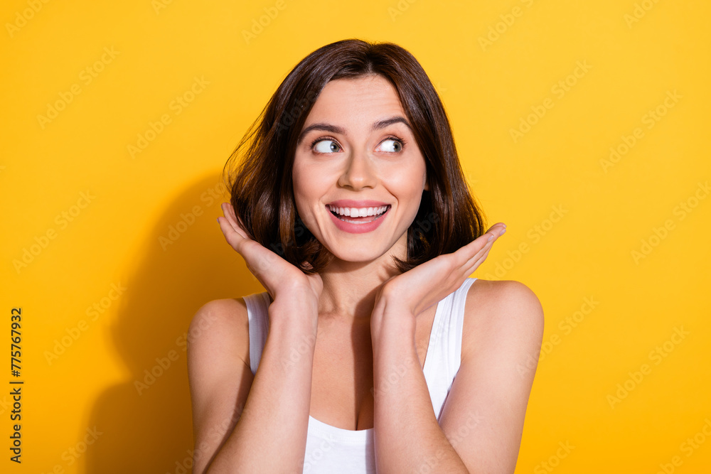 Photo portrait of attractive young girl touch hair look empty space wear trendy white outfit isolated on yellow color background Photo portrait of attractive young girl touch hair look empty space wear trendy white outfit isolated on yellow color background