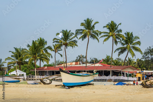 old fishing boats in sand on ocean in India on blue sky background