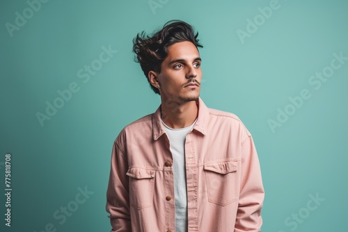 A man in a pink jacket is standing in front of a blue wall © Juan Hernandez