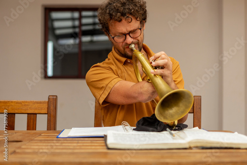 One-armed trumpeter practicing in a home courtyard photo