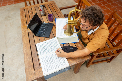 One-armed trumpeter composing music in a home courtyard photo