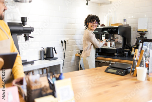 Hispanic woman barista making coffee in a cozy café setting photo