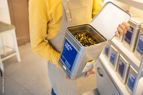 Person opening a bulk bin full of tea at store photo