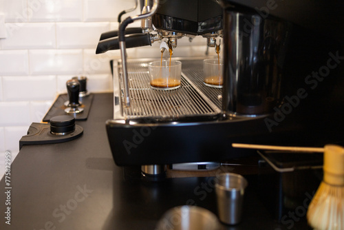 Espresso machine pouring fresh coffee into cups photo