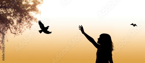 silhouette of bird flying out of Girl child hand on beautiful background.
