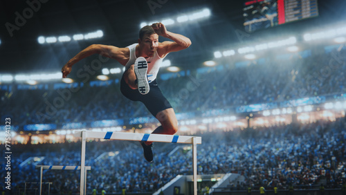 Strong Male Athlete is Running Towards an Obstacle, Hurdling, Jumping Over the Barrier in Front of a Stadium of Cheering Fans while Sprinting in a Race. Shot Of Professional Sports Performance.